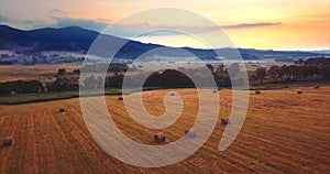 Flying above and aerial view of a field with hay stacks. Rural scene. Russia