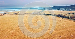 Flying above and aerial view of a field with hay stacks. Rural scene. Russia