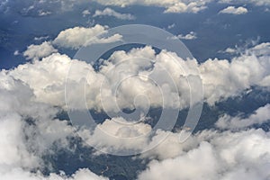 Flying above the earth and above the clouds in the territory of Kota Kinabalu, Borneo, Malaysia. Airplane window view. The plane