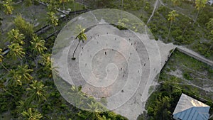 Flying above the guys playing Football on the footbal field in Tanzanian Paje village at East Zanzibar island aerial