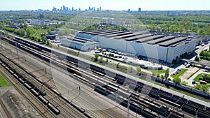 Flying above industrial railroad station with cargo trains and freight containers. Railroads and shipping container trains