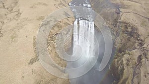 Flying Above Skogafoss Waterfall in Iceland, Water Coming From the Melting Glacier of Eyjafjallajokull Volcano. Hilly Landscape at