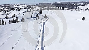 Flying above snow covered road in the mountains. Aerial 4k drone movie