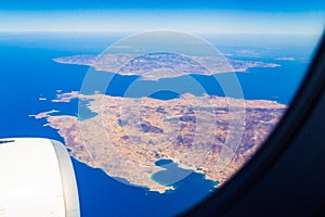 Flying airliner window Cyclades islands areal view Greece