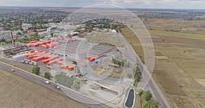 Flying around a new modern factory in orange colors. Industrial exterior of a modern factory. Modern factory top view