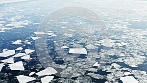 Flying backward over Baltic sea with floating ice floes, Holmsund locality, close to Umea city, Vasterbotten county, Sunny spring