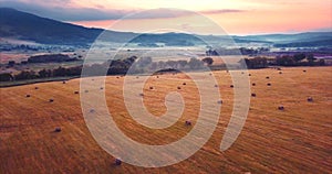 Flying backwards, aerial view of a field with hay stacks. Rural scene. Russia