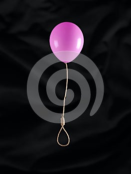 Flying balloon with gallows rope, noose or hangman knot on black background. Abstract creative emotional concept of suicide