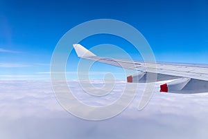 Flying into blue sky and sea of clouds and Wing of airplane with