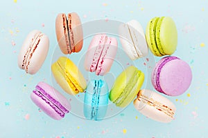 Flying cake macaron or macaroon on turquoise pastel background. Colorful almond cookies on dessert. photo