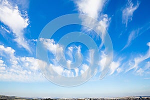 Flying cirrus clouds over blooming land