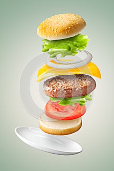 Flying classic hamburger on green background