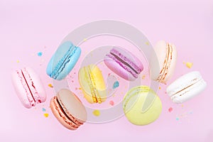 Flying colorful macaron or macaroon on pink pastel background. photo