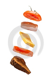 Flying deconstructed sandwich made of slices of bread, tomato, cheese and ham on a white background. Levitation of a simple photo