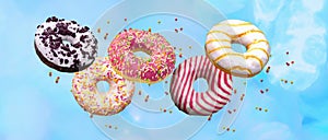 Flying doughnuts. Sweet and colourful donuts on blue background