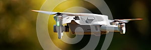 A flying drone banner. Airborne quadcopter. Also known as a drone or UAV, Unmanned Aerial Vehicle. Drone with camera.