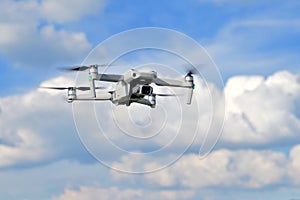 Flying drone quadcopter closeup front view with a blue sky background