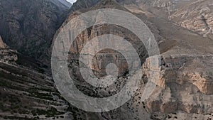 Flying eagle chase mountain stone structure desert valley village countryside landscape aerial view