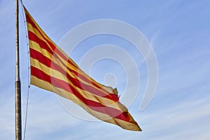 Flying flag of Catalonia against blue sky. Catalonia flag waving against clear blue sky,