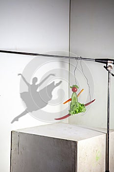 Flying food composition making beautiful ballerina drawing shadow on the wall