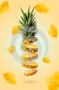 Flying fresh pineapple slices isolated on yellow background