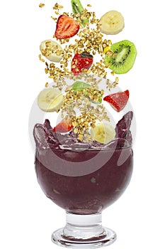 Flying fruits falling in a cup of acai