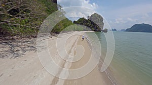 Flying green lush tropical forest trees sand beach sea ocean tourist man walking