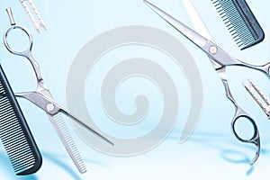 Flying hairdresser tools comb, scissors under trendy color background with copy space and soft light.