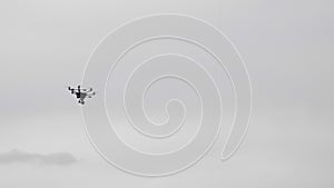Flying helicopter dron on a background of white clouds photo