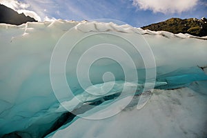 Flying by helicopter to the glacier and then Heli hiking on the glacier floor high up in the Southern Alps mountain peaks on Fox