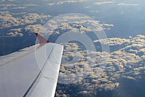 Flying High: A View from the Cabin. Wing of an airplane flying above the clouds