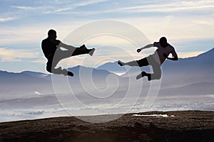 Flying, kick and karate men on mountain top for fitness, training or body, speed or power on sky background. Martial