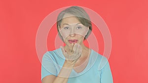 Flying Kiss by Old Woman on Red Background
