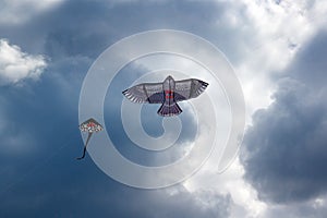 Flying kite on the cloudy blue sky background