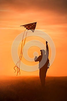 Flying a kite. Silhouette of a man with a kite against the sky. Bright sunset