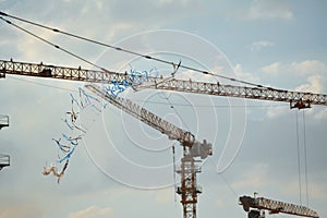 Flying kite in the sky with a background of a construction site cranes