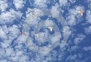 flying kites in a  blue sky full of clouds