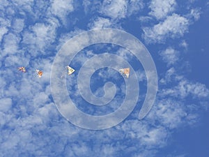 flying kites in a  blue sky full of clouds