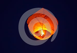 Flying lantern in the dark sky at night