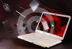 Flying in a laptop falling objects smartphone, mouse, flash, camera, tablet. Illustrative photo