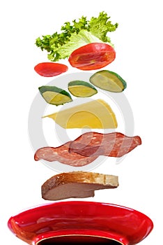 Flying layers of sandwich; ham; cheese; vegetables and red plate