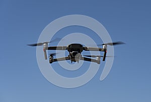 A flying mini drone recording video and photos in the sky