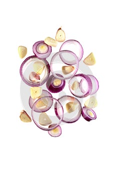 Flying onion rings and sliced garlic cloves isolated on a white background.