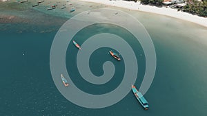 Flying over amazing white sand beach and tropical lagoon with boats