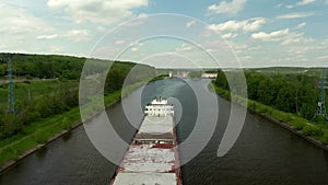 Flying over a cargo commercial ship sailing down the river