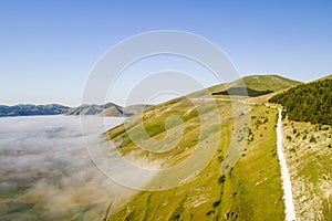 Flying over Castelluccio di Norcia, among ruins and bloom.