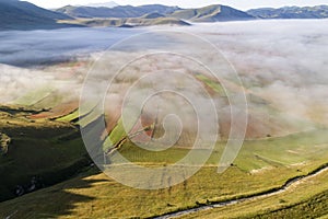 Flying over Castelluccio di Norcia, among ruins and bloom.