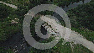 Flying over concrete sewers. Streams of water flow through concrete pipes. Polluted body of water in the park. Aerial photography.