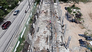 Flying Over Construction Site Of Building On The Roadside In Thailand. aerial pullback