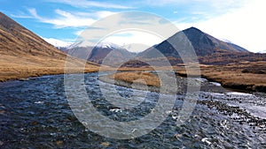 Flying Over Crystal Clear River Background Snow Capped Mountains On Autumn Day